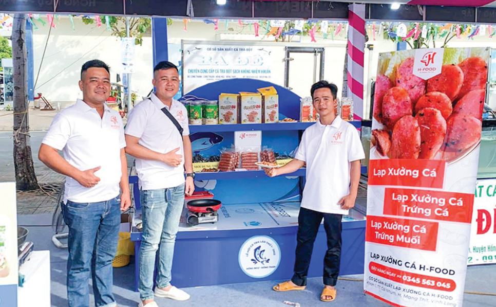 Anh Hảo (đứng giữa) giới thiệu sản phẩm lạp xưởng cá tra.