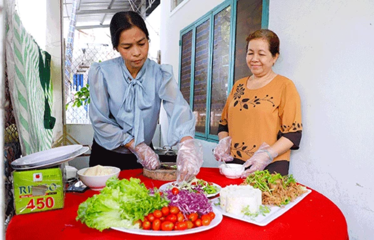Chị Mai Thị Phượng (bên trái) cùng thành viên Tổ liên kết “Dịch vụ nấu ăn lưu động hỗ trợ việc làm cho phụ nữ dân tộc” chuẩn bị món ăn giao khách.